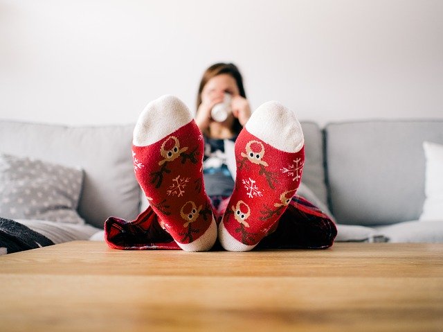 Woman sitting with feet up at home. 